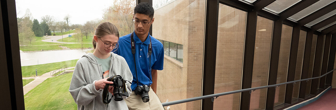 Students Abigail Cullum and Enan Chediak review photo on camera screen