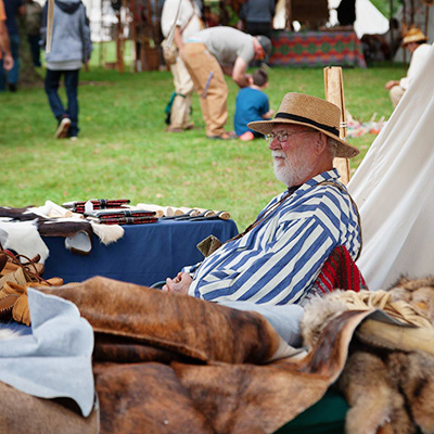 Man sitting at 'Buckskinners Village' at Southern Illinois Hunting and Fishing Days