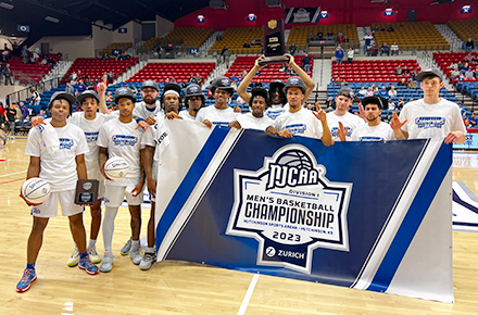 JALC Men's Basketball team with NJCAA Division 1 Men's Basketball Championship banner and National Champion award