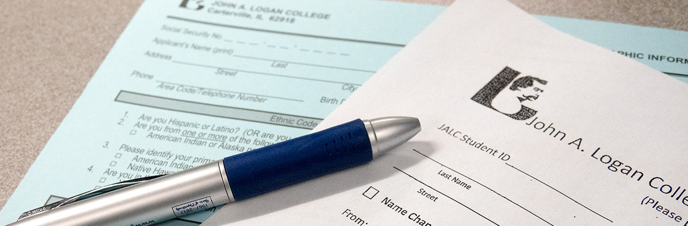 Two John A. Logan College forms with pen sitting on top of them.