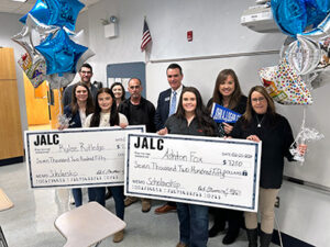 John A. Logan College presents scholarship checks.