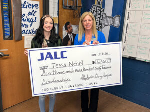 Tessa Nehrt is presented with a scholarship check from JALC.