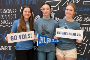 Students pose with signs at New Student Orientation Day