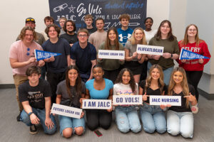 Group of students pose with signs at New Student Orientation Day