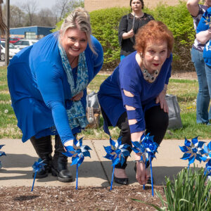 Jo Poshard and guest put blue pinwheels into the ground for the Poshard Child Abuse Prevention Month Kickoff