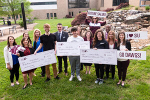 SIU Provost scholarship winners holding their checks next to administration from JALC and SIU