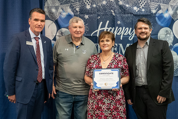 Retiring Professor of Business Lora Hines with certificate standing next to JALC College President Dr. Kirk Overstreet, board member Jake Rendleman, and Assistant Professor of Mathematics Andrew Carr.