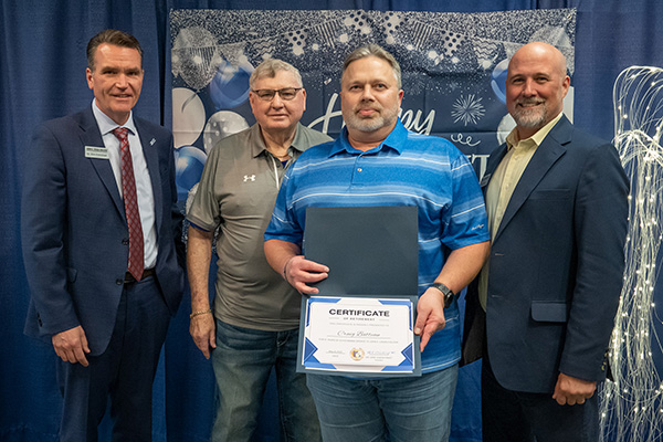 Retiring Director of Desktop Technology Craig Batteau with certificate standing next to JALC College President Dr. Kirk Overstreet, board member Jake Rendleman, and Assistant Vice President of Integrated Technology Scott Elliott.