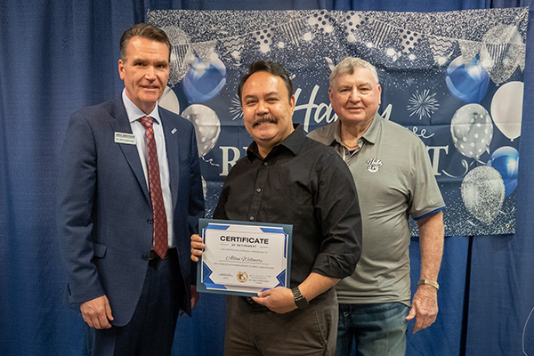 Retiring Chief of Campus Police Allan Willmore with certificate standing next to JALC College President Dr. Kirk Overstreet, and board member Jake Rendleman.