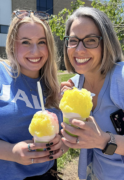 Alumni Engagement & Affinity Programs Coordinator Mikaylan Roach and Grant Manager Gretchen Cudworth hold snow cones at the JALC Employee Appreciation Luncheon.