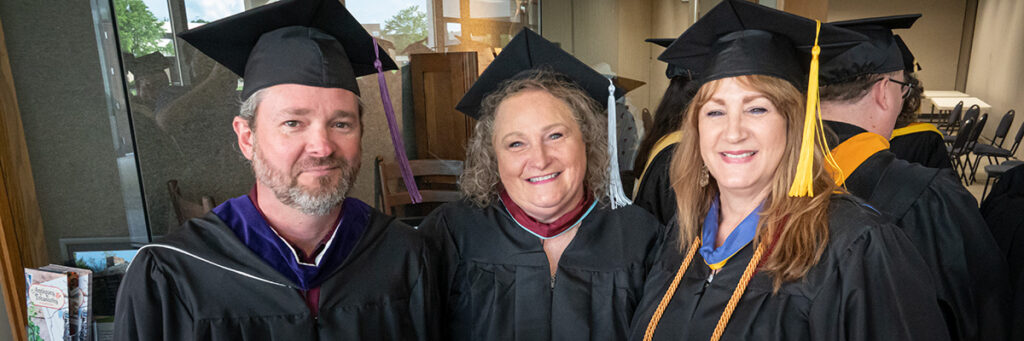 Brennan Stover, Leslie Harmon-McKenzie, and Connie Robinson with graduation regalia.