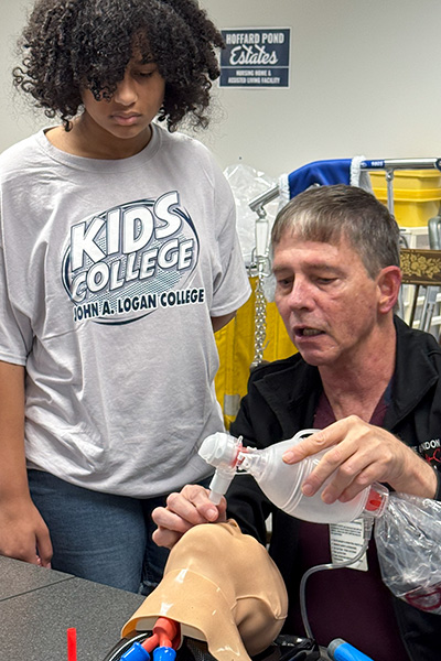 JALC instructor doing a demonstration for participant in KIDS COLLEGE event.