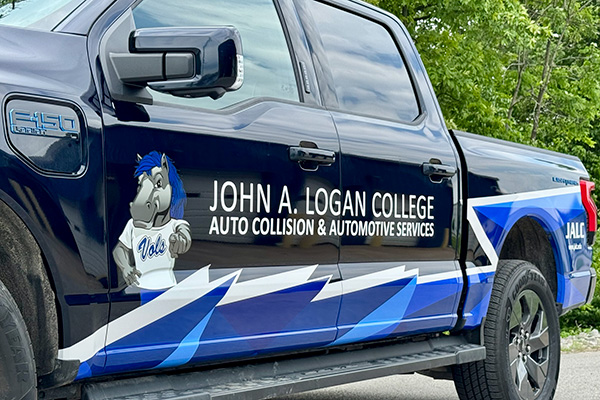 JALC's EV truck with college branding.