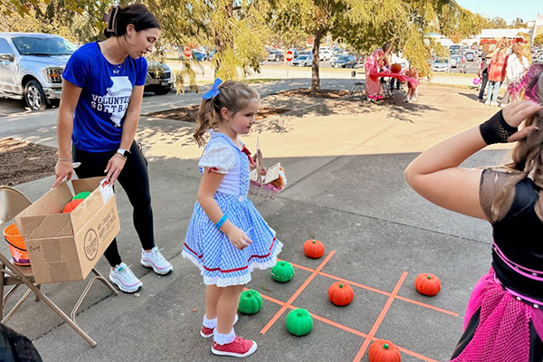 Child playing pumpkin tic-tac-toe at Not-So-Scary Trick or Treat event at John A. Logan College.