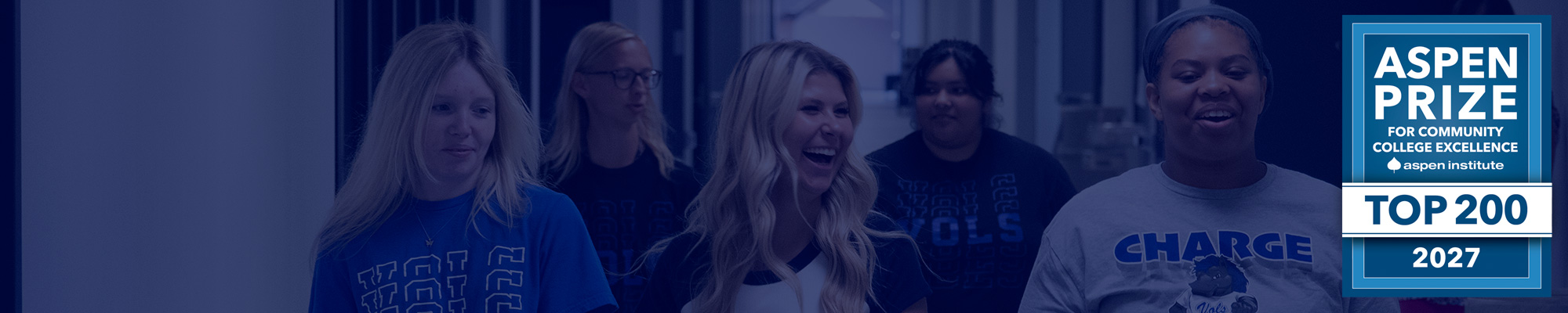Students walking in hallway with ASPEN PRIZE FOR COMMUNITY COLLEGE EXCELLENCE aspen institute TOP 200 2027 badge overlaid.