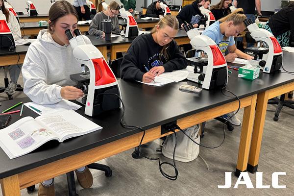 Students in biology classroom with microscopes at JALC.