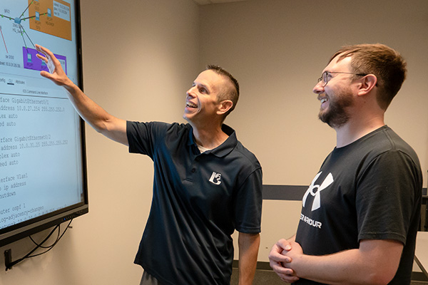 JALC Assistant Professor of Computer Information Systems, Roger Jeter, discusses information on screen with student.