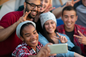 Young adults taking a group selfie.