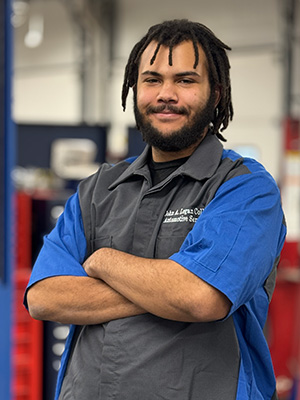 Evan Giles in John A. Logan College Automotive shirt with arms crossed.
