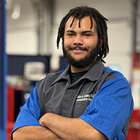 Evan Giles in John A. Logan College Automotive shirt with arms crossed.