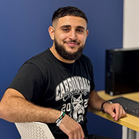 JALC student Omar Naser sitting in chair.
