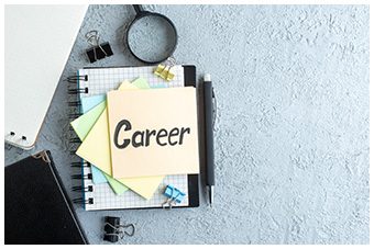 Note pads, pen, clips and magnifying glass. The word Career is written on the top note pad.
