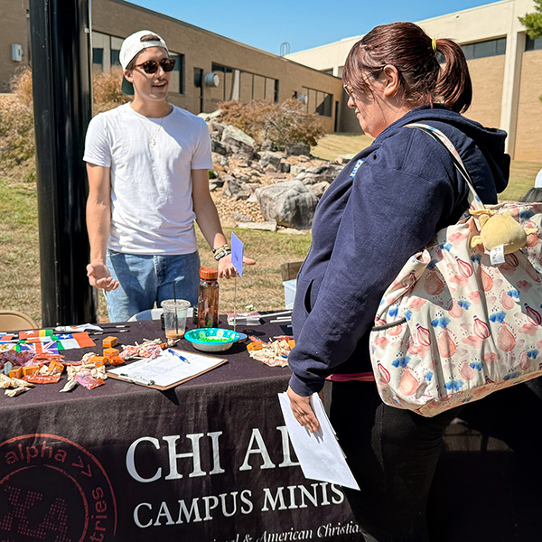 Club member and student interact at the Chi Alpha table during Loganpalooza at John A. Logan College.