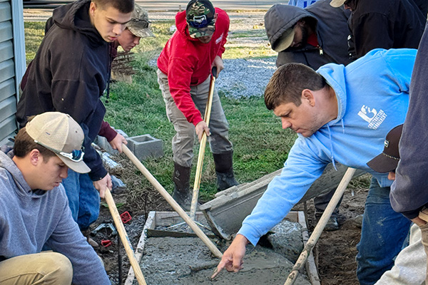 JALC Assistant Professor of Construction Management Wade Dover working with students on a concrete pour.