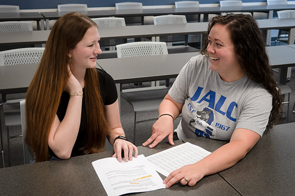 JALC Instructor of Accounting and Business Markella Rutherford and student review finance information shown on papers.